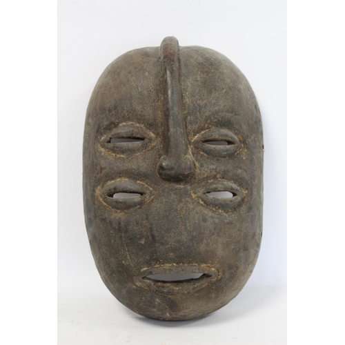 359 - African tribal carved wooden mask of oval form with four pierced lidded eyes, central raised nose an... 