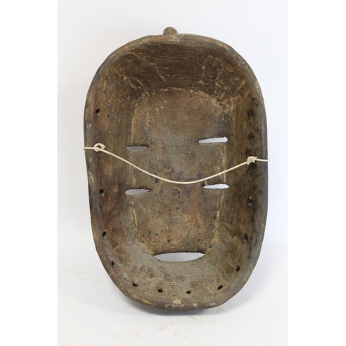 359 - African tribal carved wooden mask of oval form with four pierced lidded eyes, central raised nose an... 