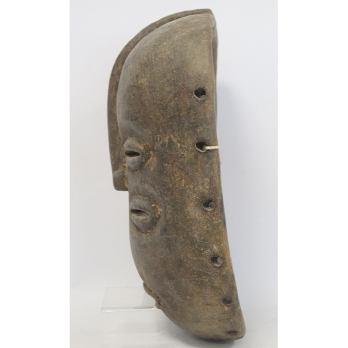 359 - African tribal carved wooden mask of oval form with four pierced lidded eyes, central raised nose an... 