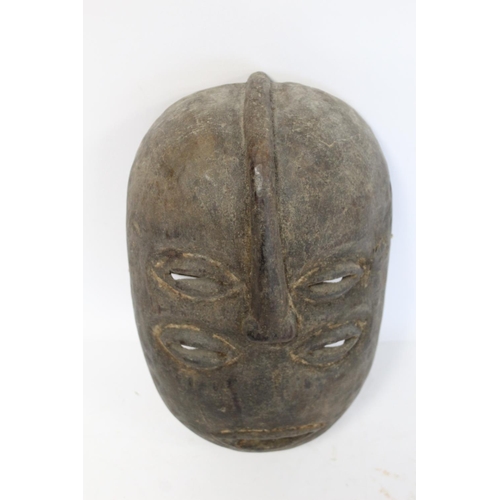 359 - African tribal carved wooden mask of oval form with four pierced lidded eyes, central raised nose an... 