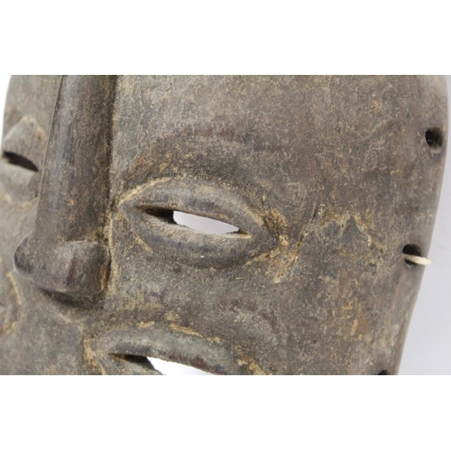 359 - African tribal carved wooden mask of oval form with four pierced lidded eyes, central raised nose an... 