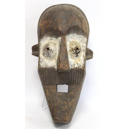 360 - African tribal carved wooden mask of large elongated form with arched brow, conical ribbed eyes, tri... 