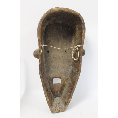 360 - African tribal carved wooden mask of large elongated form with arched brow, conical ribbed eyes, tri... 