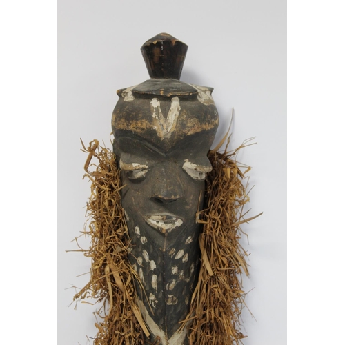 363 - African tribal carved wooden mask of elongated form, with carved and painted facial features, border... 