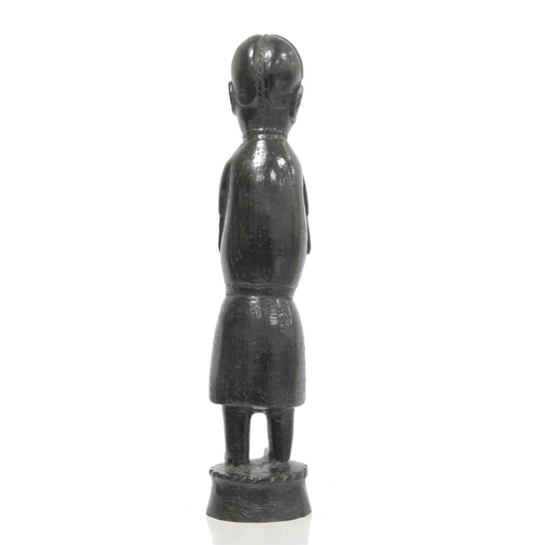 369 - Ethnic, probably African, carved ebony standing figure of a man (European missionary / priest?) on c... 