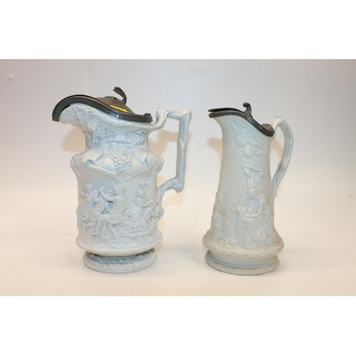 70 - Two Victorian ewers decorated in high relief with figures and grape vines, 22cm & 20cm. (2)
