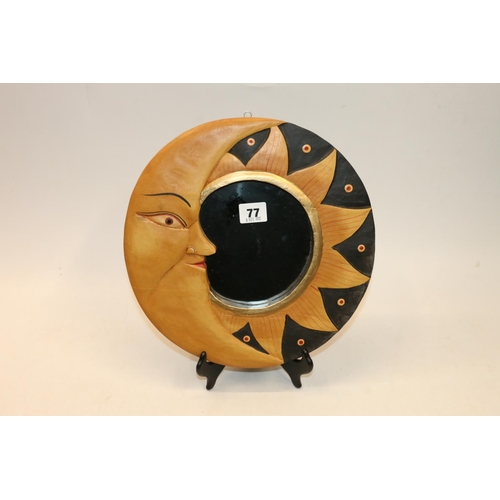 77 - Mirror with carved and painted sun and moon frame, 29cm diameter.