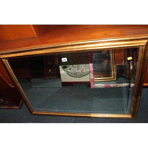 702 - Gilt framed rectangular wall mirror, 101cm x 72cm.