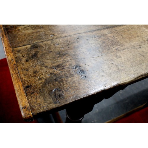 404 - 17th century style oak refectory table, with fixed plank top, above a carved frieze, raised on turne... 