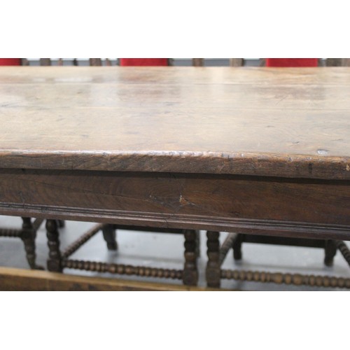 404 - 17th century style oak refectory table, with fixed plank top, above a carved frieze, raised on turne... 