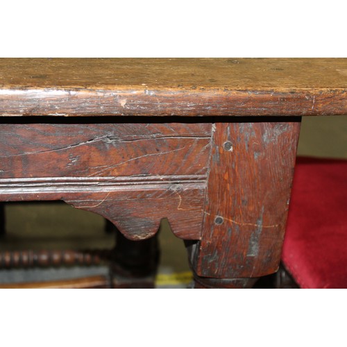 404 - 17th century style oak refectory table, with fixed plank top, above a carved frieze, raised on turne... 