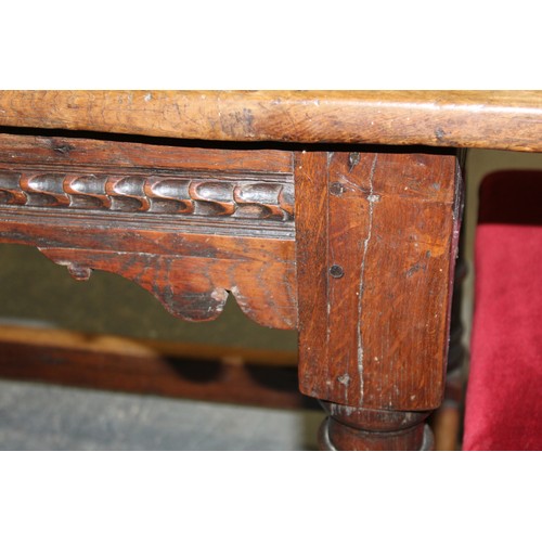 404 - 17th century style oak refectory table, with fixed plank top, above a carved frieze, raised on turne... 