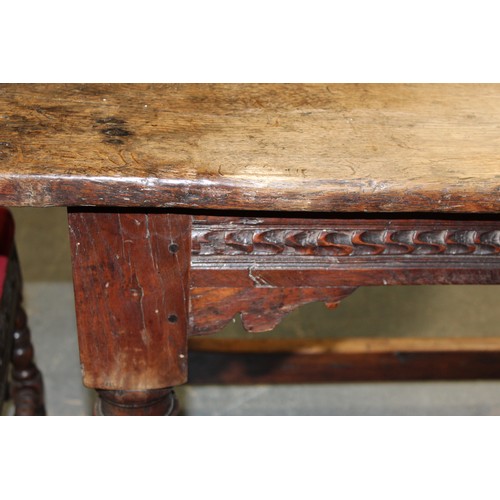 404 - 17th century style oak refectory table, with fixed plank top, above a carved frieze, raised on turne... 