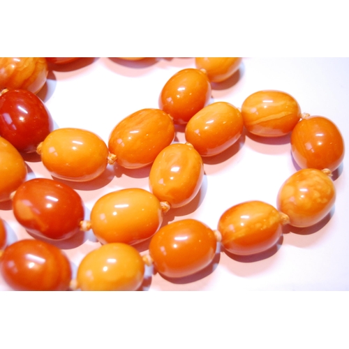 75 - Amber necklace of ovoid beads, 153g.