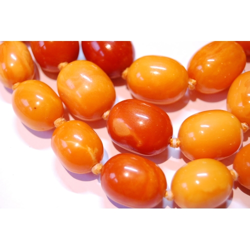 75 - Amber necklace of ovoid beads, 153g.