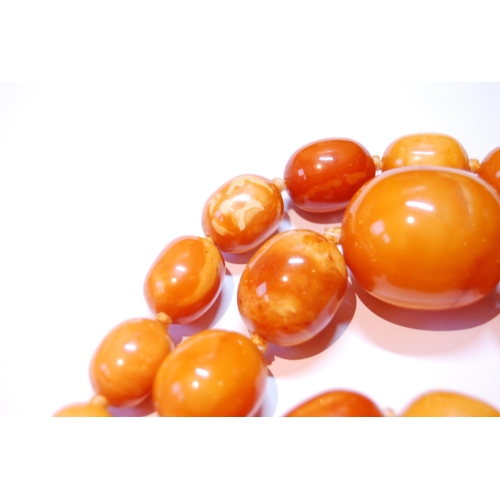 75 - Amber necklace of ovoid beads, 153g.