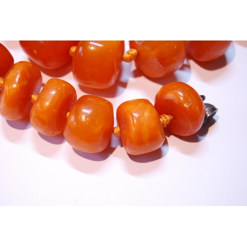 76 - Amber bead necklace of variegated circular beads, 146g.