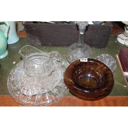 214 - Glass centrepiece with rounded edge and footed base, along with a decanter and plates.