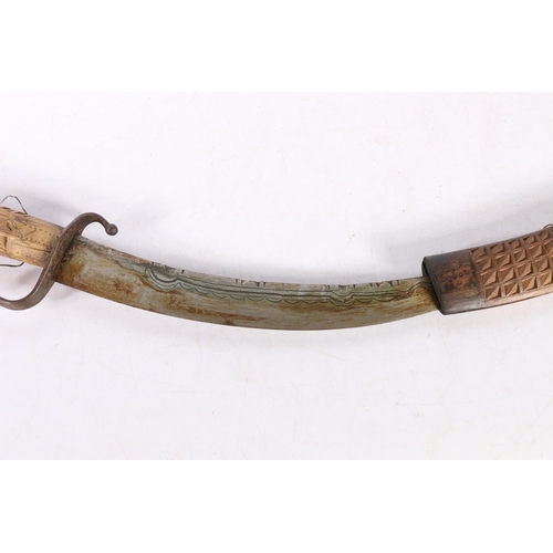 107 - Moroccan Nimcha dagger, the hilt & sheath carved with geometric design, 51cm.