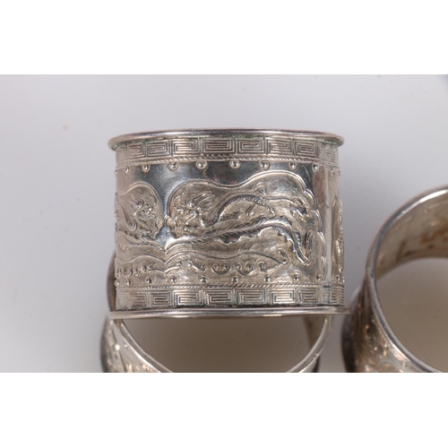 483 - Set of three Chinese white metal napkin rings with relief Kylin dragon decoration, no markings, unte... 