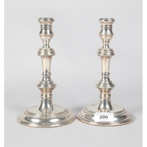 200 - Pair of Elizabeth II hallmarked silver turned column candlesticks; raised on stepped circular bases;... 