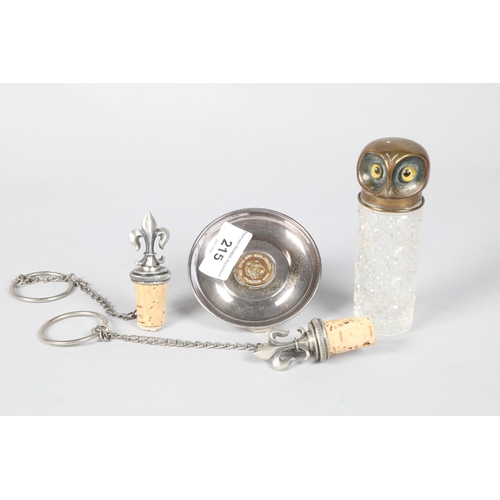 215 - Brass 'Owls Head' topped glass bottle; together a silver plate pin dish insert with brass medal and ... 