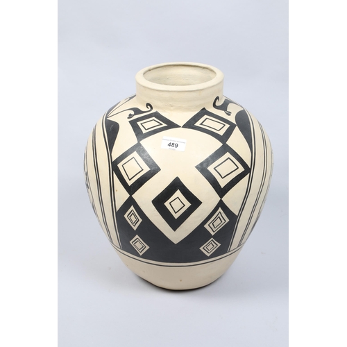 489 - Painted clay tribal vase; decorated with abstract pattern; 45cm high