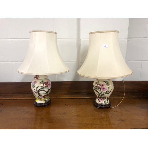 642 - Pair of floral painted porcelain table lamps; raised on hardwood bases 