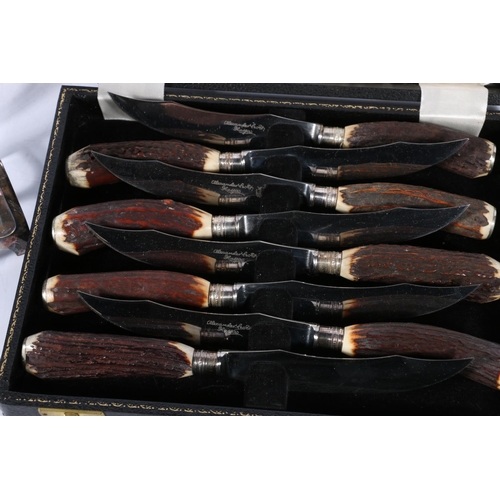 25 - Alexander Soeth horn-handled knives, cased, a pair of silver-plated toast racks, and a pair of silve... 