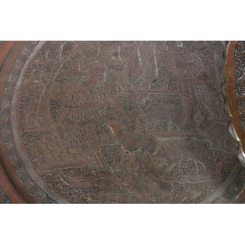 14 - Two Indian copper chargers, one decorated with mythical beast, the other decorated with a farming sc... 