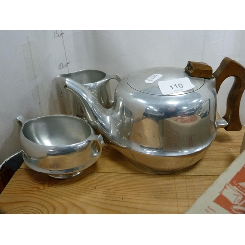 110 - Three-piece Picquot ware tea set, pair of brass candlesticks, travel iron etc.