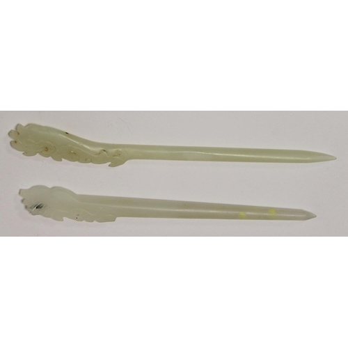 239 - Two Chinese pale celadon jade hair pins, each with pierced and carved ends, 17cm and 16cm long. ... 