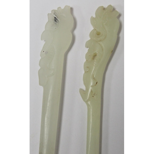 239 - Two Chinese pale celadon jade hair pins, each with pierced and carved ends, 17cm and 16cm long. ... 