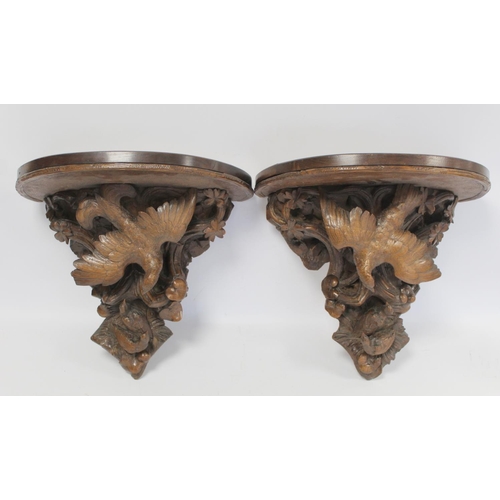 248 - Pair of Victorian or Edwardian walnut wall brackets, the demi lune tops on tapered supports profusel... 