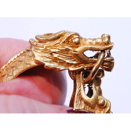 101 - Chinese gold bracelet in two halves, modelled as dragons grasping a ring, Chinese character and othe... 