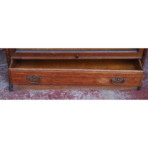 414 - Oak sectional bookcase by Gunn Furniture Company, with three glazed sections above a long drawer, st... 