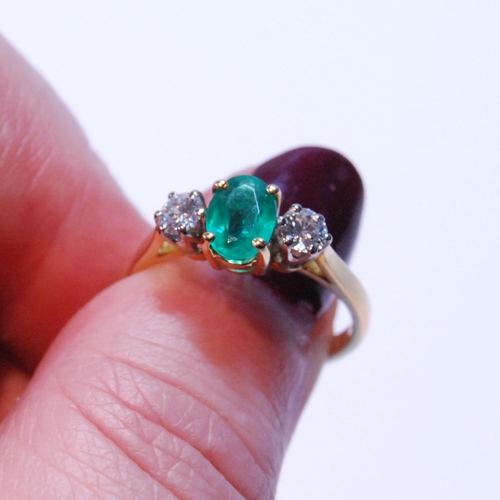 91 - Diamond and emerald three-stone ring, the oval emerald approximately .72mm x 5mm, between two brilli... 