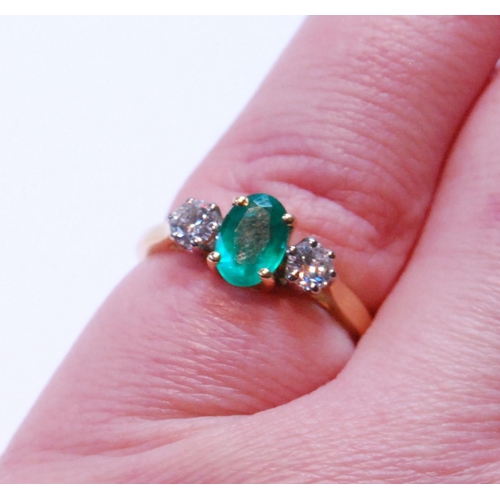 91 - Diamond and emerald three-stone ring, the oval emerald approximately .72mm x 5mm, between two brilli... 