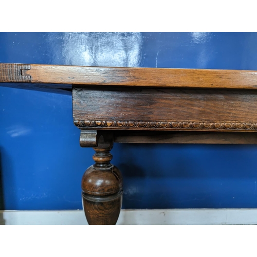 475 - An oak refectory table with egg and dart detail to the apron on cup and cover supports and trestle b... 