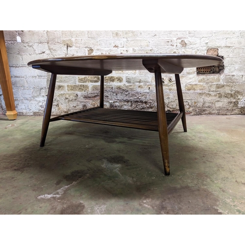 483 - Ercol dark elm top oval coffee table with turned supports united by spindle lower tier, 44cm high x ... 