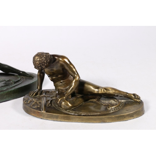 287 - Two 20th century bronze castings of a fallen Roman soldier, modelled sat upon his Gladius type sword... 