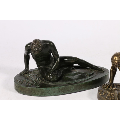 287 - Two 20th century bronze castings of a fallen Roman soldier, modelled sat upon his Gladius type sword... 