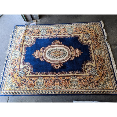 486 - Prado Oriental Keshan carpet with floral decorated central medallion on blue field within foliate bo... 