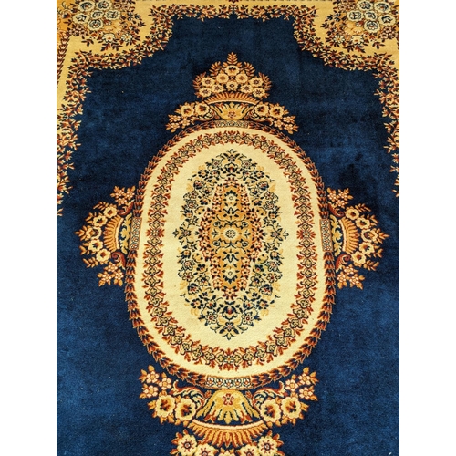 486 - Prado Oriental Keshan carpet with floral decorated central medallion on blue field within foliate bo... 