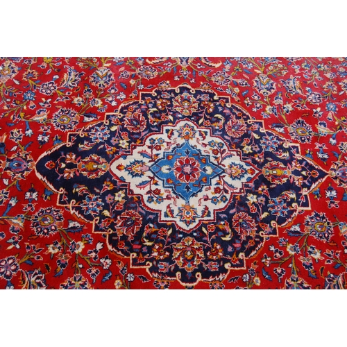 364 - Persian Tabriz carpet with a large medallion to the centre, all over foliate swags to the border, on... 