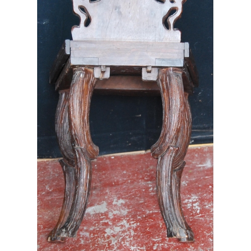 417 - Black Forest carved oak hall chair, the naturalistic back rest applied with flowerheads and leaves, ... 