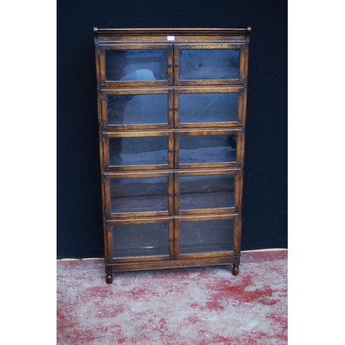 423 - Oak bookcase with two glazed doors to each section, 161cm high, 89cm wide and 26cm deep.