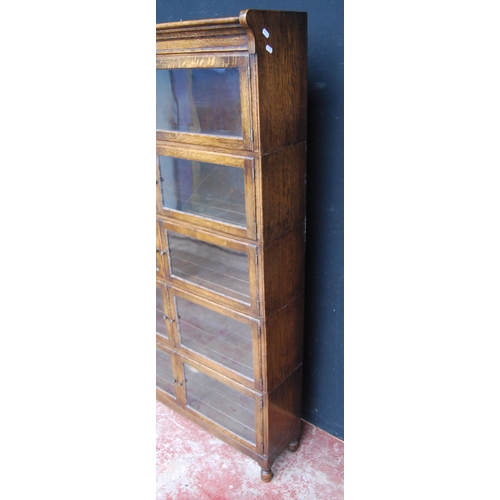 423 - Oak bookcase with two glazed doors to each section, 161cm high, 89cm wide and 26cm deep.