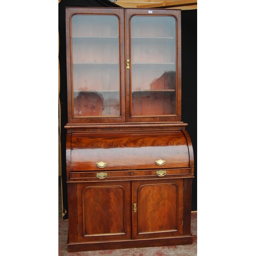 424 - Victorian mahogany library bookcase on cylinder bureau base, the bookcase section with two glazed do... 