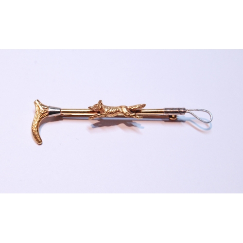 126 - 9ct gold hunting brooch modelled as a fox on a riding crop, stamped '375', 5g gross.